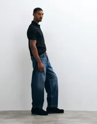 loose jeans in dark wash blue with pleats and buckle